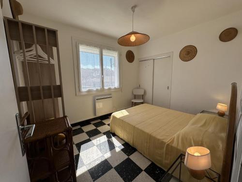 une chambre avec un lit et un sol à carreaux dans l'établissement Dune, à Vieux-Boucau-les-Bains