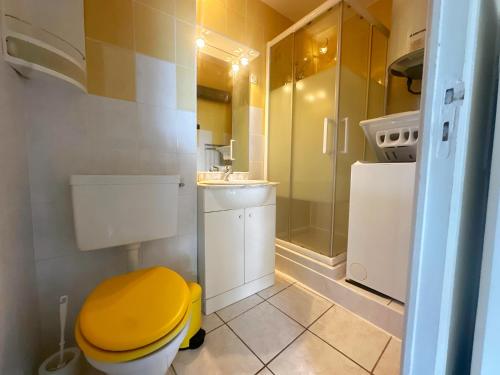La salle de bains est pourvue d'une douche et de toilettes jaunes. dans l'établissement Cocon au Grau-du-Roi Calme, lumineux, à 200m de la plage, au Grau-du-Roi
