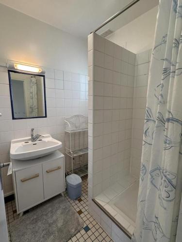 une salle de bain avec un lavabo et une douche dans l'établissement Dune, à Vieux-Boucau-les-Bains