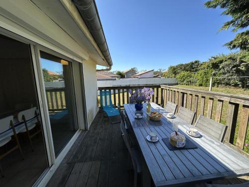une terrasse en bois avec une table sur un balcon dans l'établissement Dune, à Vieux-Boucau-les-Bains