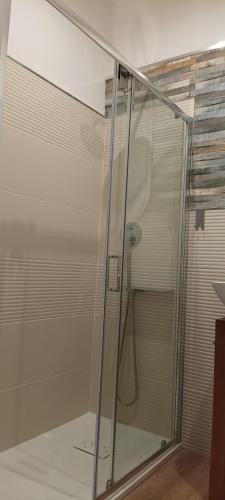 a shower with a glass door in a bathroom at Eos affittacamere in Castelsardo