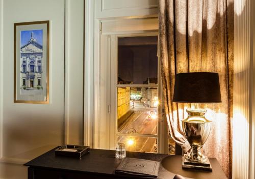 a living room with a lamp and a window at Hotel Bellotto in Warsaw