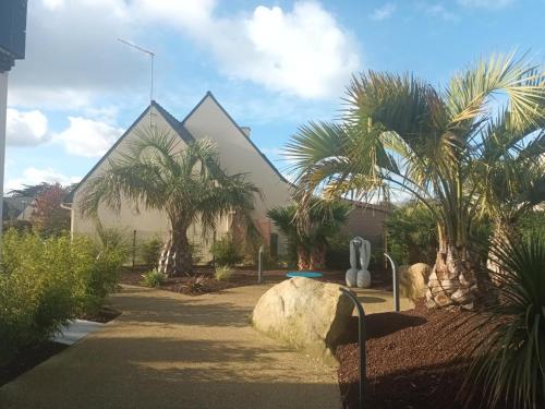 a church with palm trees in front of a building at Le spa de la palmeraie in Penvénan