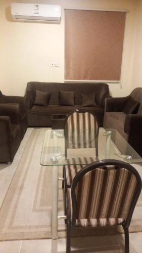 a living room with a glass table and a couch at دار السلام للشقق المخدومة الجوف دومة الجندل in Dawmat al Jandal
