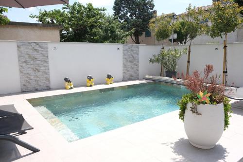 - une piscine avec un vase de fleurs à côté dans l'établissement LS7-429 - SUASSO Jolie villa avec piscine privée en centre ville de Salon de Provence 4 personnes, à Salon-de-Provence