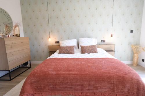 une chambre avec un grand lit avec une couverture rouge dans l'établissement LS7-429 - SUASSO Jolie villa avec piscine privée en centre ville de Salon de Provence 4 personnes, à Salon-de-Provence