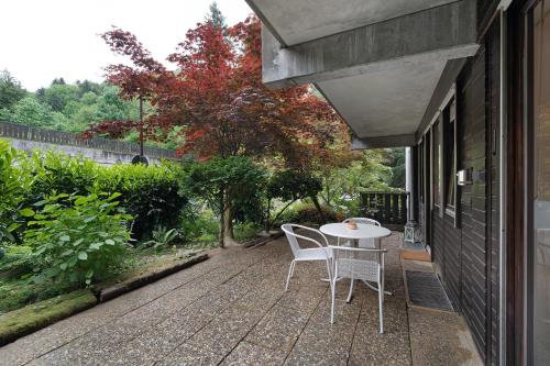 un patio con mesa y sillas en el lateral de una casa en Ferienwohnung Wanderschön, en Sasbachwalden