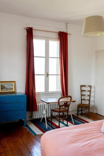 une chambre avec un lit, un bureau et une fenêtre dans l'établissement Villa Les Chesneaux, vue mer Mers-les-Bains, à Mers-les-Bains