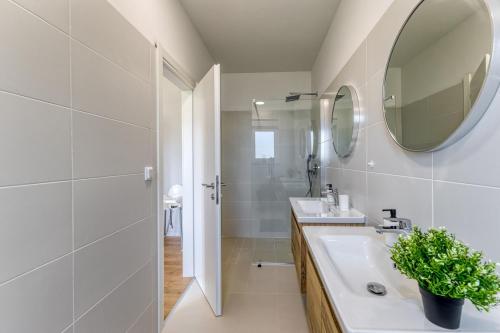 a white bathroom with a sink and a mirror at Villa Marina in Kršan