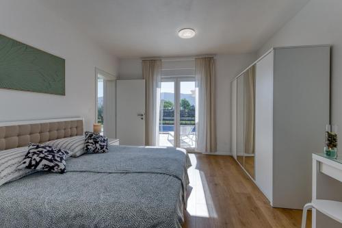 a bedroom with a bed and a large window at Villa Marina in Kršan