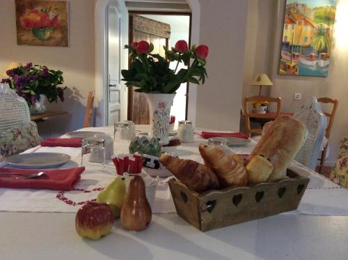 a table topped with a table with a box of bread at Clos des Iris in Moustiers-Sainte-Marie