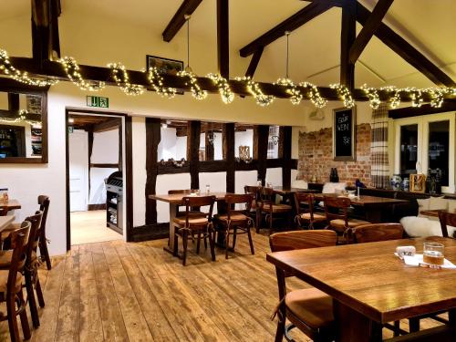 a restaurant with wooden tables and chairs and lights at Landhotel Kahltalmühle in Alzenau in Unterfranken