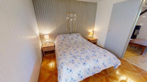 a bed in a room with two lamps on two tables at Maison Juloucam in Éguzon-Chantôme