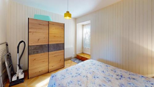 a bedroom with a bed and a large wooden closet at Maison Juloucam in Éguzon-Chantôme