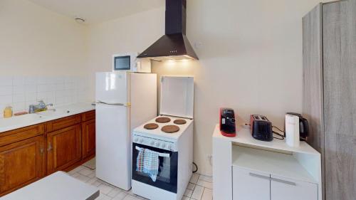 a kitchen with a white refrigerator and a stove at Maison Juloucam in Éguzon-Chantôme