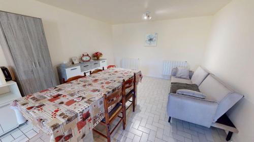 a room with a table and a couch and a chair at Maison Juloucam in Éguzon-Chantôme