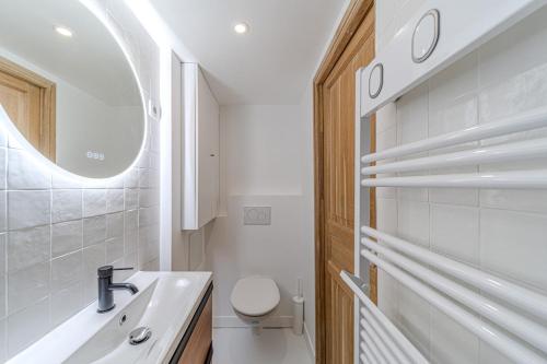 une salle de bain avec un lavabo, des toilettes et un miroir dans l'établissement Duplex élégant et calme, plein centrre, à Lyon