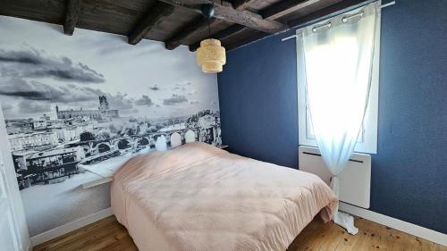 a bedroom with a bed with a painting on the wall at Cocon chaleureux au cœur d'Albi in Albi