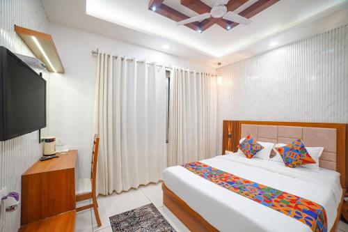 a bedroom with a bed and a flat screen tv at FabHotel Eminent in Bhopal