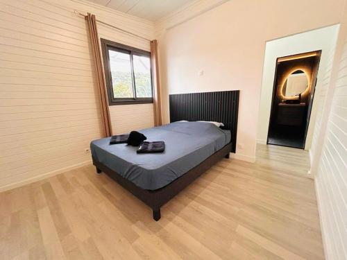 a bedroom with a bed in a room with a window at La Kaz Bon'R in Étang-Salé