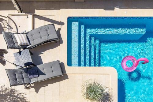 an overhead view of a swimming pool with lounge chairs and a pool at Villa Luxoria in Peroj