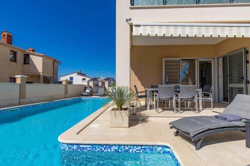 a swimming pool in the backyard of a house at Villa Luxoria in Peroj