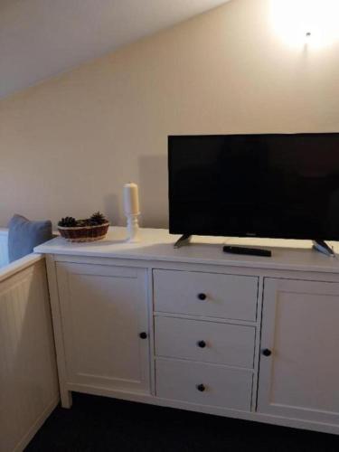 a white dresser with a flat screen tv on top of it at Wellness apartmán Frymburk D403 Čtvrté patro in Frymburk