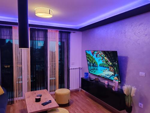 Vrnjačka BanjaにあるApartman ARMANE 4 star LUX & Free EVchargeのテレビとテーブルのあるリビングルーム