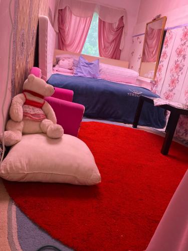 a room with two beds and a teddy bear sitting on a pillow at Zoldovezet in Budaörs