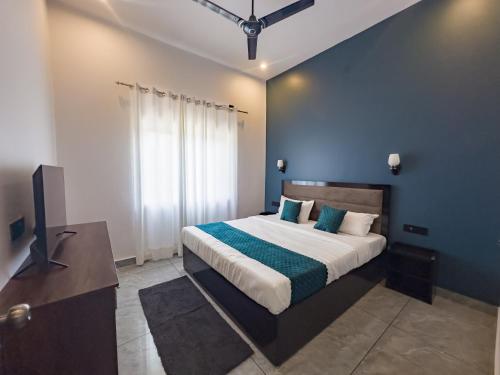 a bedroom with a bed and a flat screen tv at Bageecha inn in Dehradun