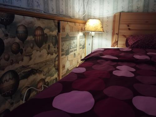 a bedroom with a purple comforter on a bed at City Center Rooms in Budapest