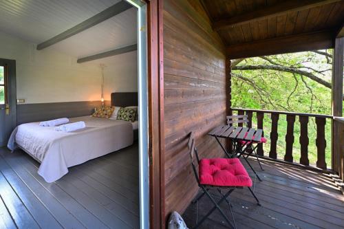 a room with a bed and a table on a porch at La Grande Via, ospitalità in Maremma in Montemerano