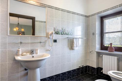 a bathroom with a sink and a toilet and a mirror at Locanda Casa Bardacchino in Mango