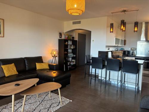 un salon avec un canapé et une table et une cuisine dans l'établissement PAOLINA C1- vue mer- proche commerces, à Sari-Solenzara