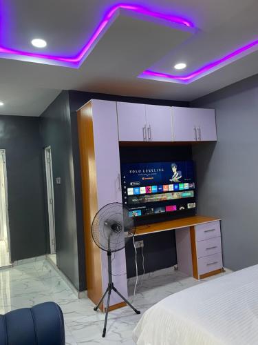 a room with a fan and a room with a bed at Umbrella Properties hotels and apartments - Moniya in Ibadan
