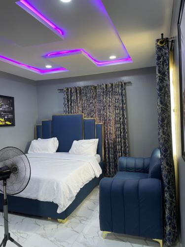 a bedroom with a blue bed and a blue chair at Umbrella Properties hotels and apartments - Moniya in Ibadan