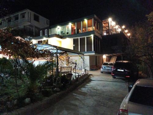 a house with a car parked in a parking lot at night at hill-fort kutaisi in Kutaisi