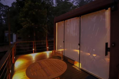 a deck with a wooden table and a bench at João de Barro - Deck Tiny House in Mairiporã