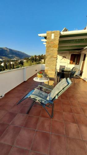 a patio with a chair and a table on a roof at Green Oasis in Lámira