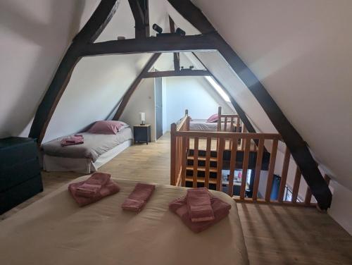a attic room with a bed and a staircase at Gite Argoules piscine chauffée in Rue