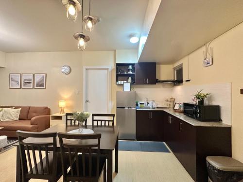 a living room and a kitchen with a table and chairs at 2-Bedroom Condo Unit with Balcony at Centrio Tower beside Ayala Centrio Mall Downtown CDO in Cagayan de Oro