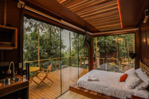 a room with a bed on a balcony at João de Barro - Deck Tiny House in Mairiporã