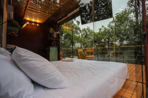 a large bed in a room with a large window at João de Barro - Deck Tiny House in Mairiporã