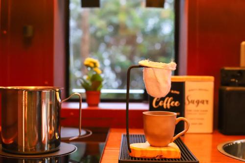 a piece of cake is being held above a coffee cup at João de Barro - Deck Tiny House in Mairiporã