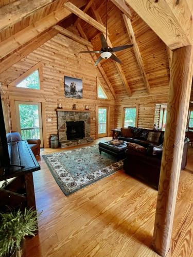 a living room with a couch and a fireplace at Awesome Log Cabin in Massanutten Resort in McGaheysville