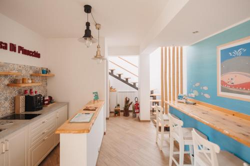 a kitchen with white cabinets and a blue wall at La Casa Di Pinocchio in Enna