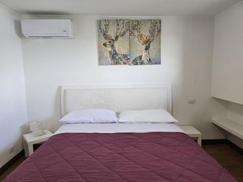 - une chambre avec un lit et une couverture violette dans l'établissement SEASIDE COTTAGE LADISPOLI CERRETO, à Ladispoli