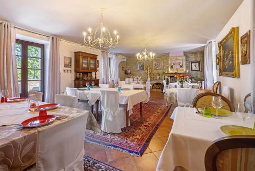 a dining room with white tables and a chandelier at Locanda Casa Bardacchino in Mango