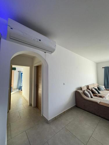 a living room with a couch and a ceiling fan at Marassi in Dawwār Abū Maḩrūs