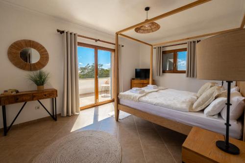 une chambre avec un lit et une grande fenêtre dans l'établissement Traumhafte Finca am Es Trenc, à Ses Covetes